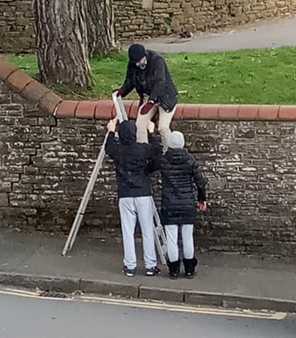  People set up a step ladder to climb the wall to get into Belle Vue Park in Newport