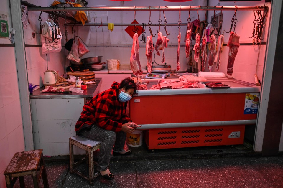 A meat vendor waits for a customer at a market in Wuhan