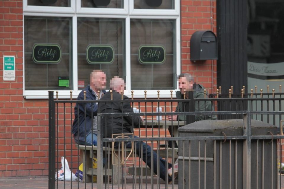  Three men appear to flout social distancing rules outside a pub