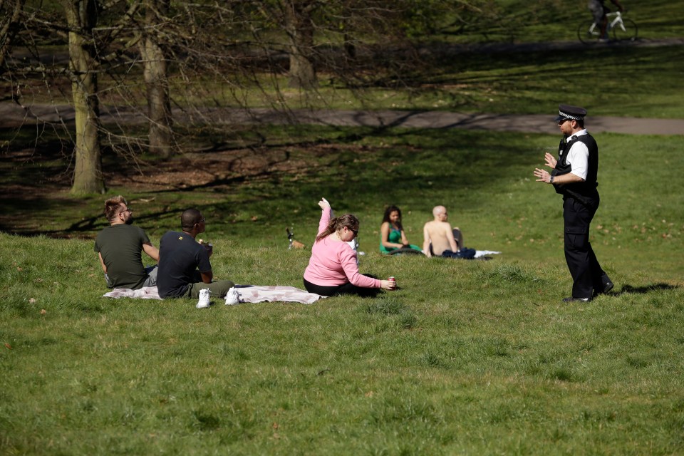  Police speak with a group of sun bathers in Greenwich Park after the government threatens to bring stricter lockdown measures