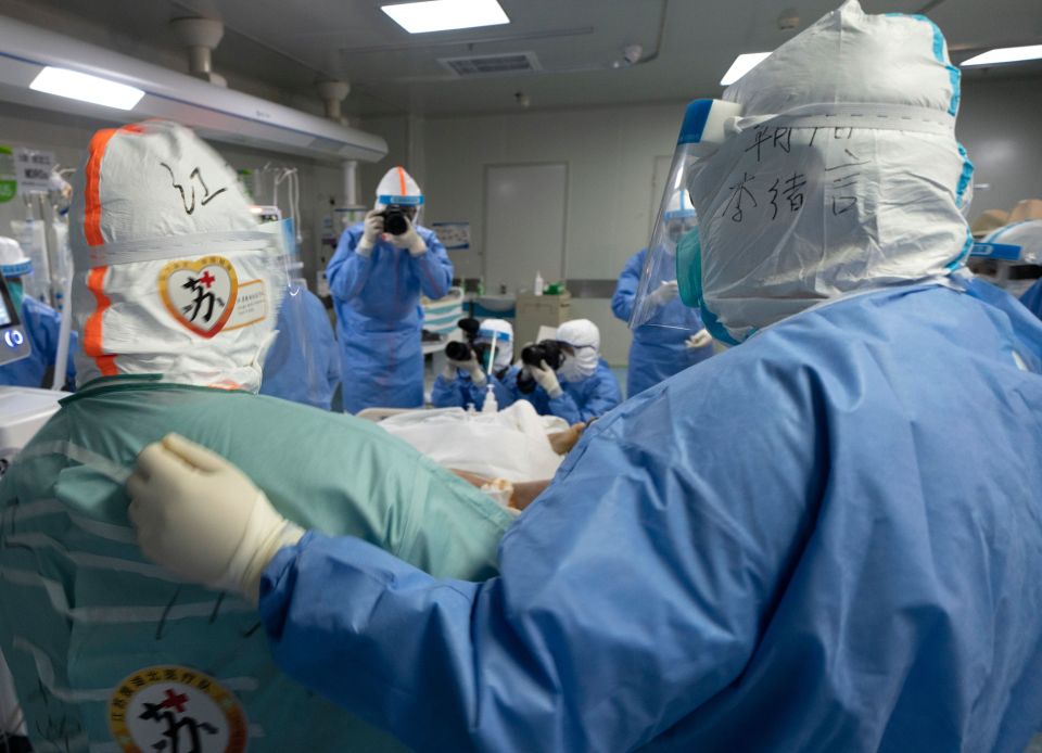  Medical staff pat each other after a coronavirus patient in Wuhan recovered on April 5