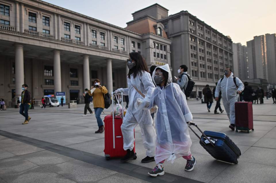  Travellers in protective clothing arrived for an early morning train at Wuhan station after the lockdown was lifted