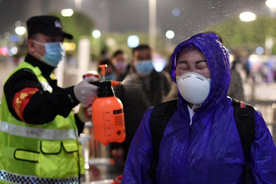 A state official sprays down a citizen of Wuhan 