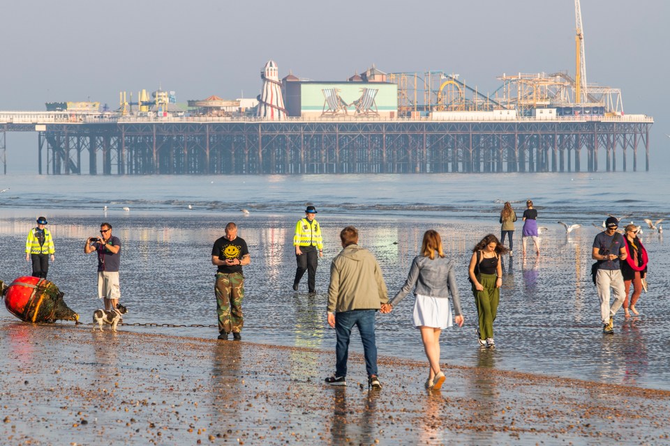  Police in Brighton are seen outnumbered as they try to move dozens of people away from the beach