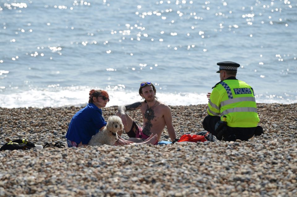  A police officer moves on members of the public in Brighton during the lockdown