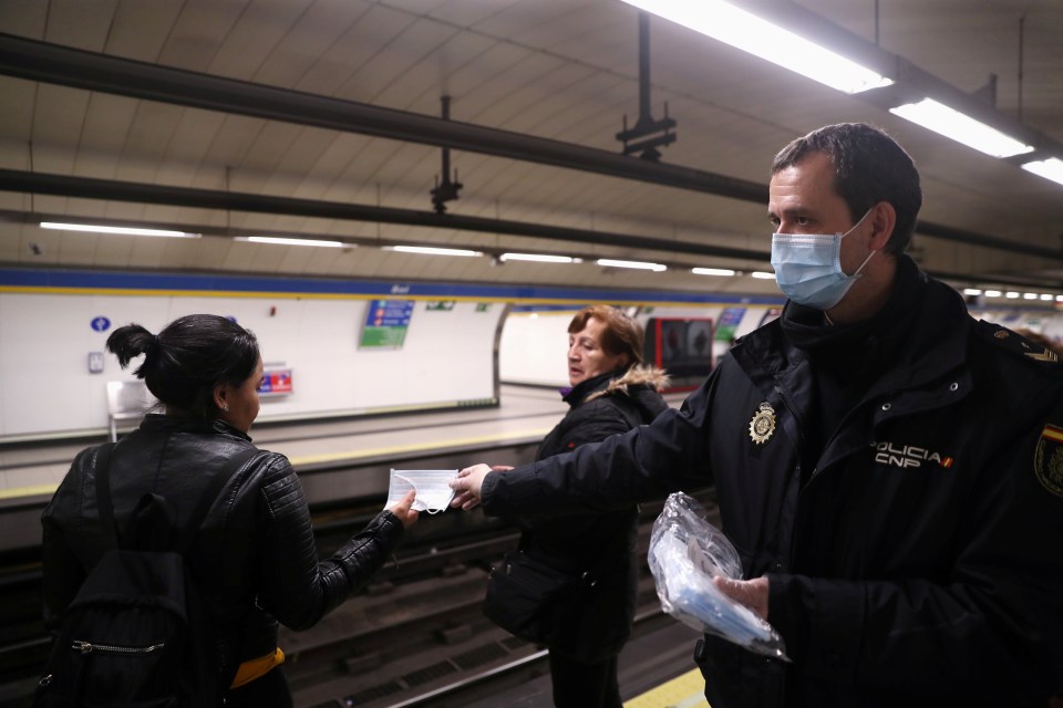  Passengers on the Madrid metro are handed masks on their way to work