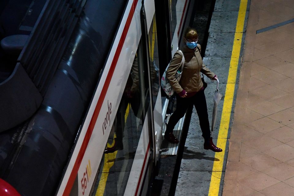  An early morning commuter wearing a face mask comes out of a train at the Atocha Station in Madrid