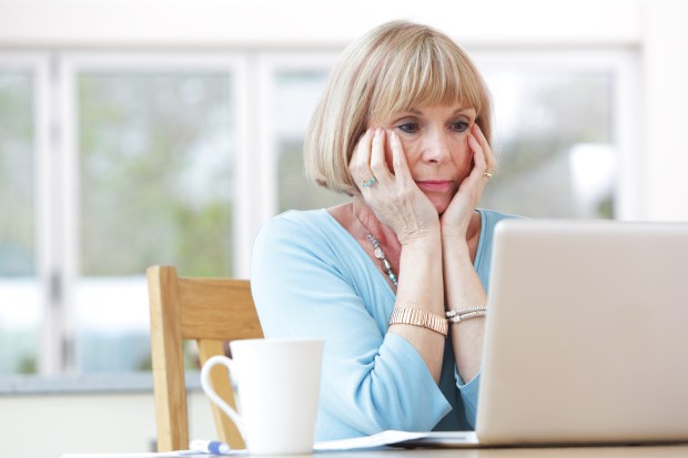 Old lady looking worried at laptop