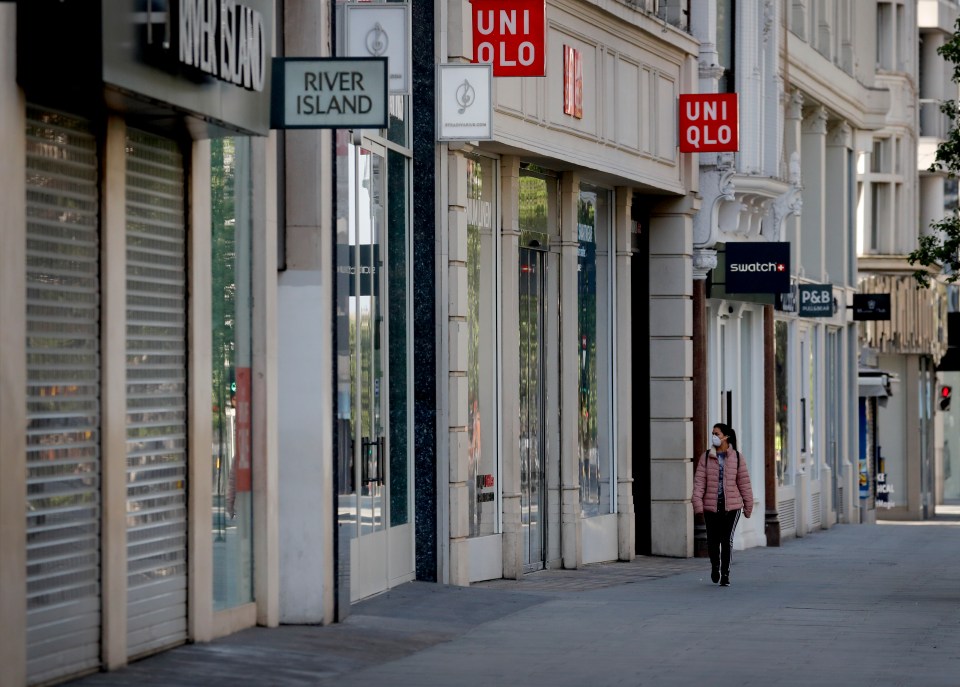  A woman wearing a face mask walks past closed shops on Oxford Street in London on April 15