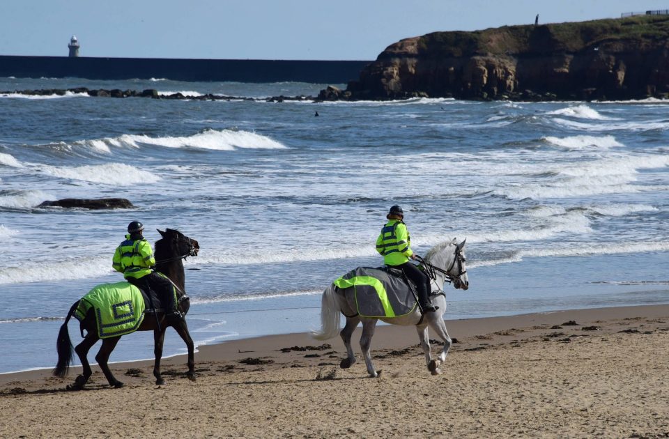  Northumbria Police officers on horseback patrol Tynemouth Longsands beach