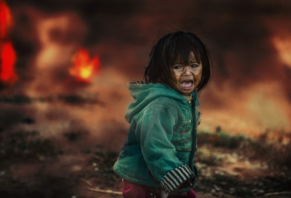  This photo by @thaibana.vn shows a child crying as the landscape burns around her