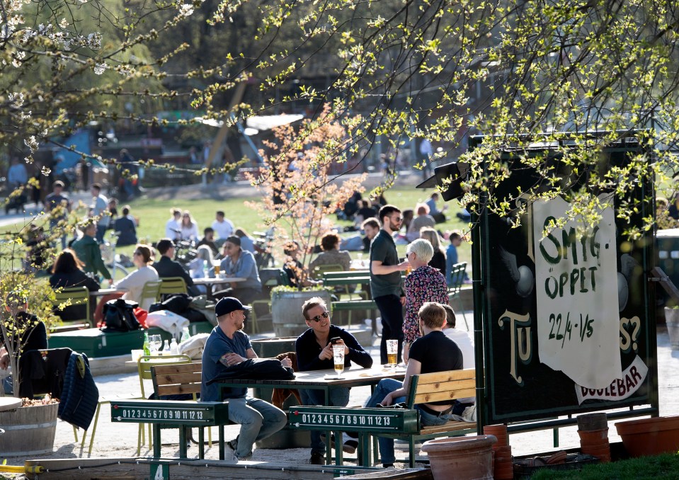  People gather in a cafe to enjoy the warm spring weather in Stockholm, Sweden, despite coronavirus death toll rise