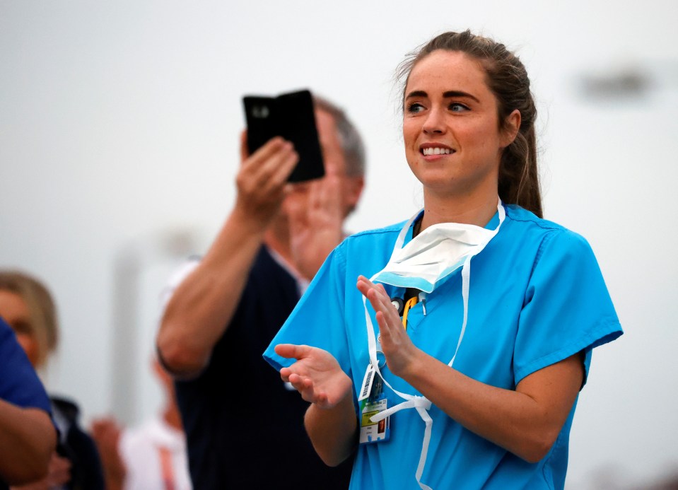  An NHS worker applauds outside the Aintree University Hospital during the Clap for Carers