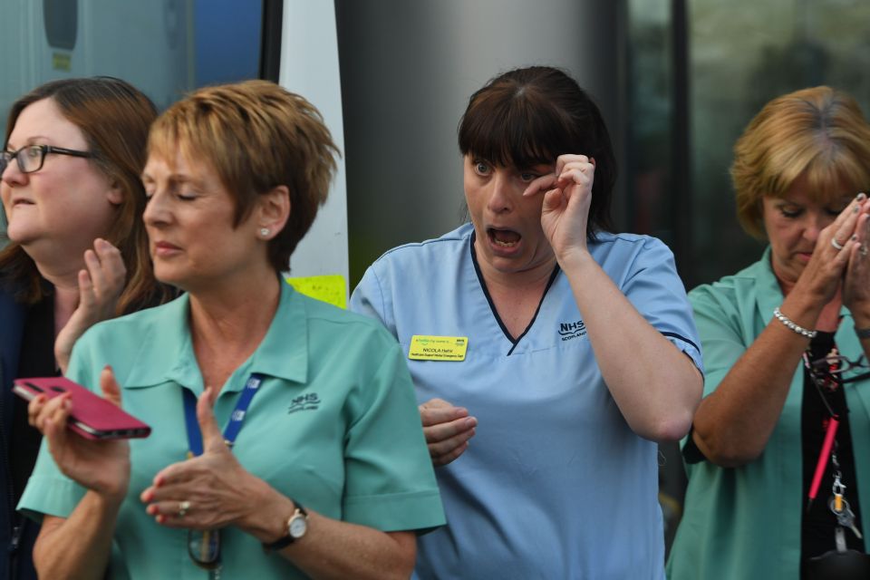  An NHS worker wipes away a tear during the clap