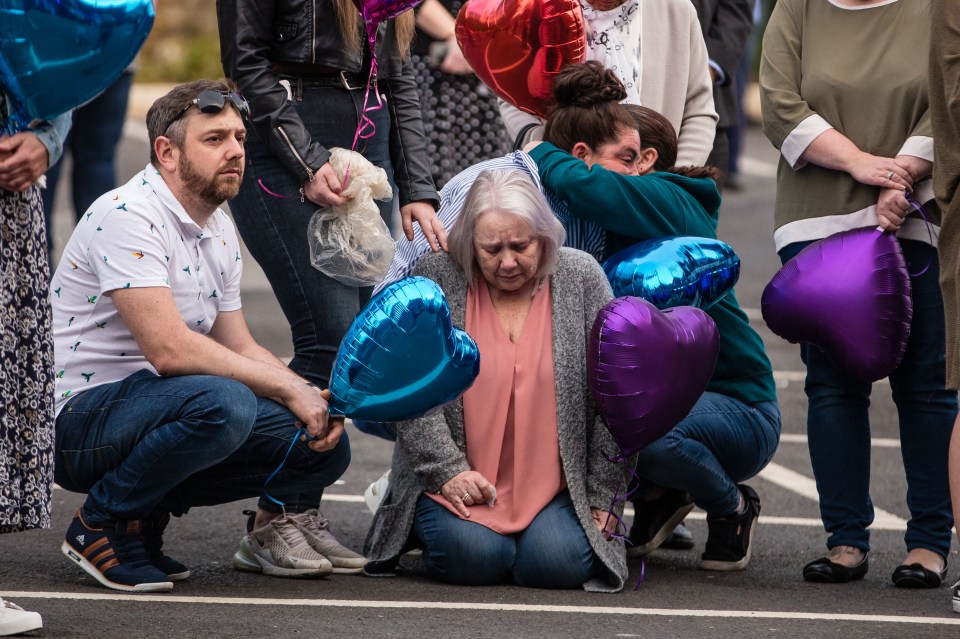  A woman falls to her knees and is consoled by family members at Wigan Royal Infirmary during the Clap For Carers