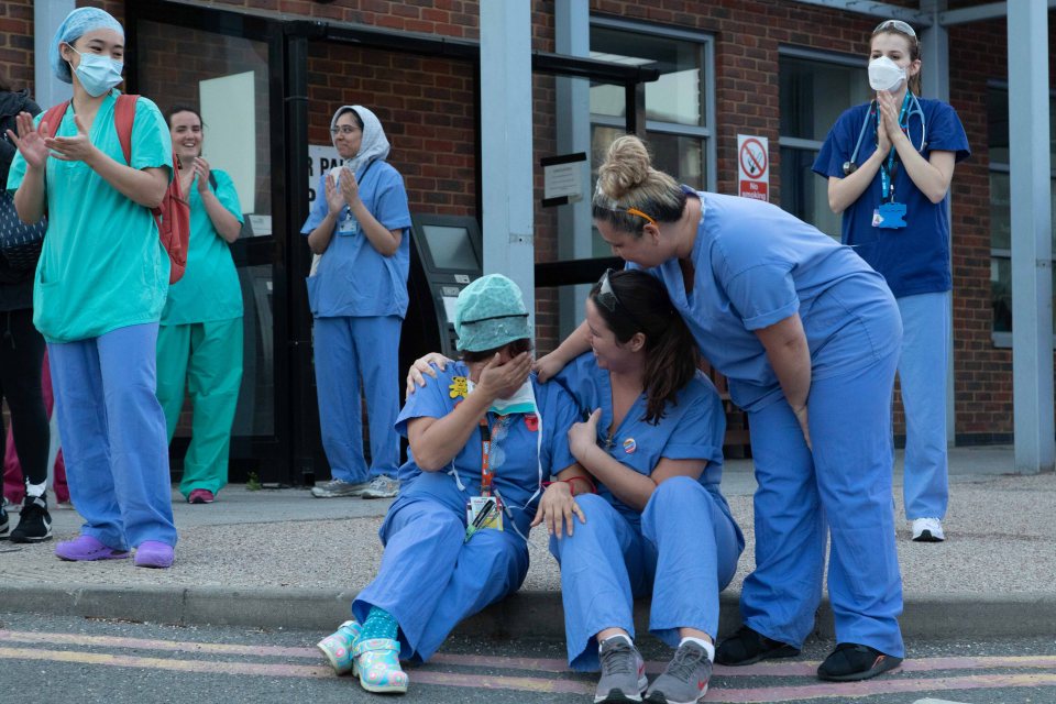  A nurse is comforted by colleagues after she is emotionally overcome during the 8pm clap for carers outside Kingston Hospital in Surrey