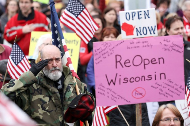 Protesters hold signs calling for Wisconsin to re-open