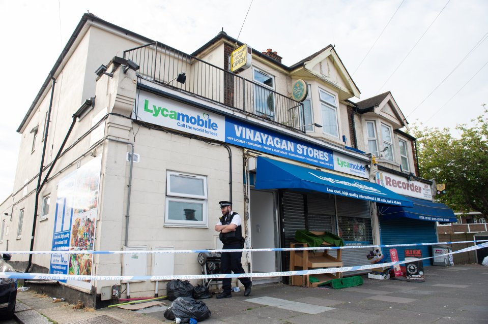  Police are seen standing guard outside the home where the two children were fatally stabbed in Ilford last night