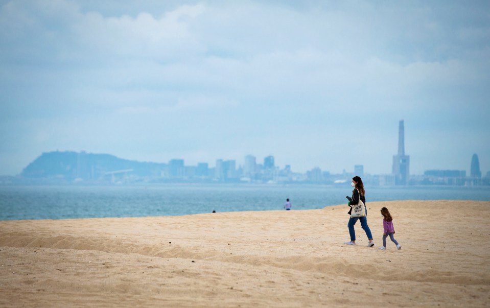  A woman walks with her daughter in Barcelona after restrictions were eased to allowed kids to go outside