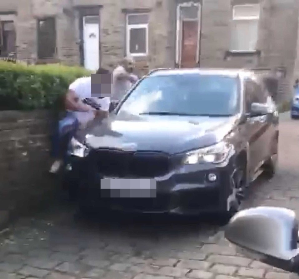 The driver of the BMW is seen trying to run over a man in a street in Halifax