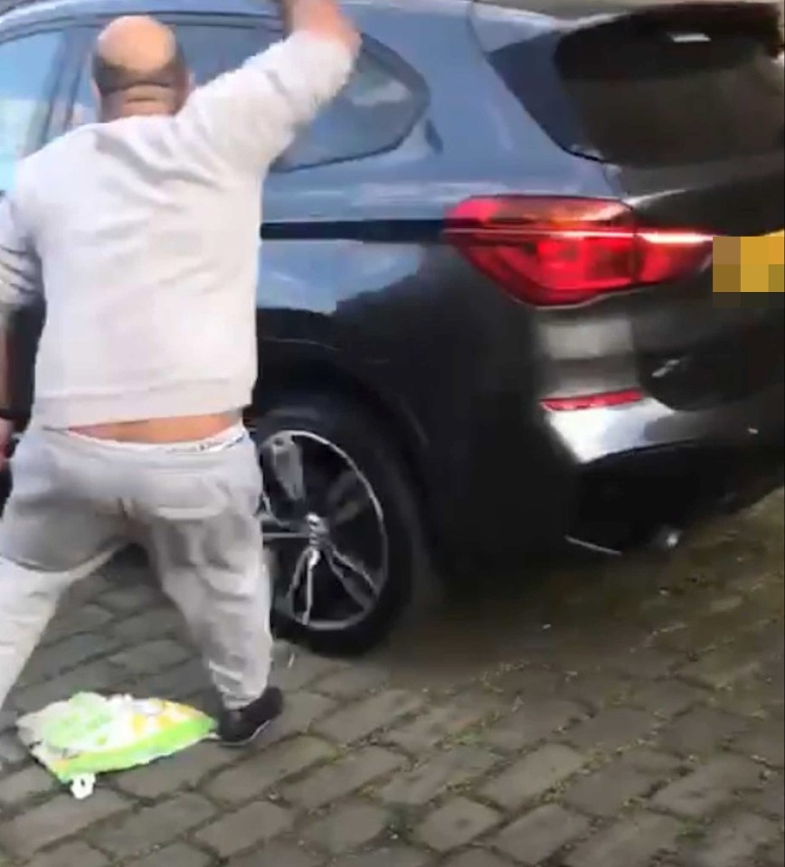 The knifeman is seen furiously slashing at the car