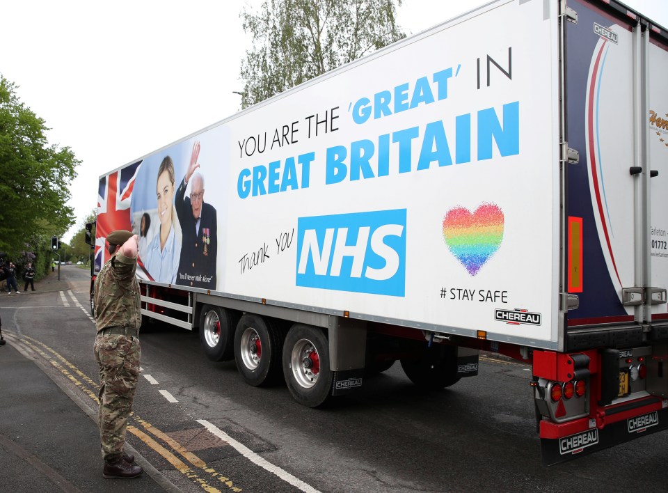  An Army officer salutes as a truck displays a message of thanks to the NHS and WWII veteran Captain Tom Moore on his 100th birthday