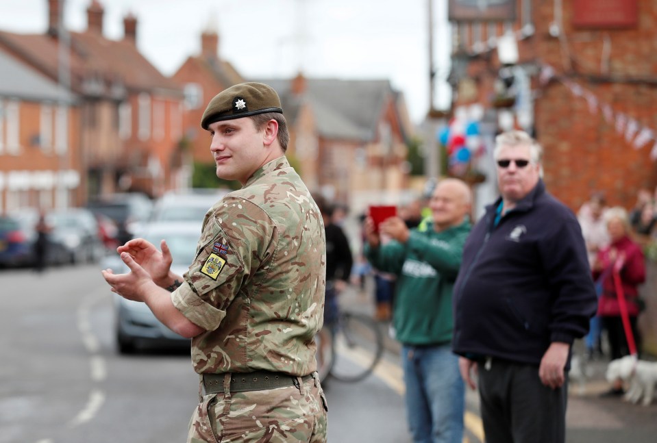  A soldier applauds for Captain Tom Moore in Marston Moretaine