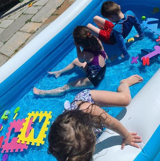 In the snap, the trio cooling down in a paddling pool