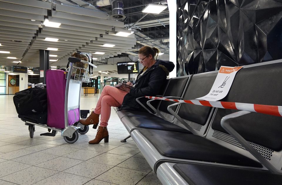  A passenger waits on seats that have been cordoned off at the airport