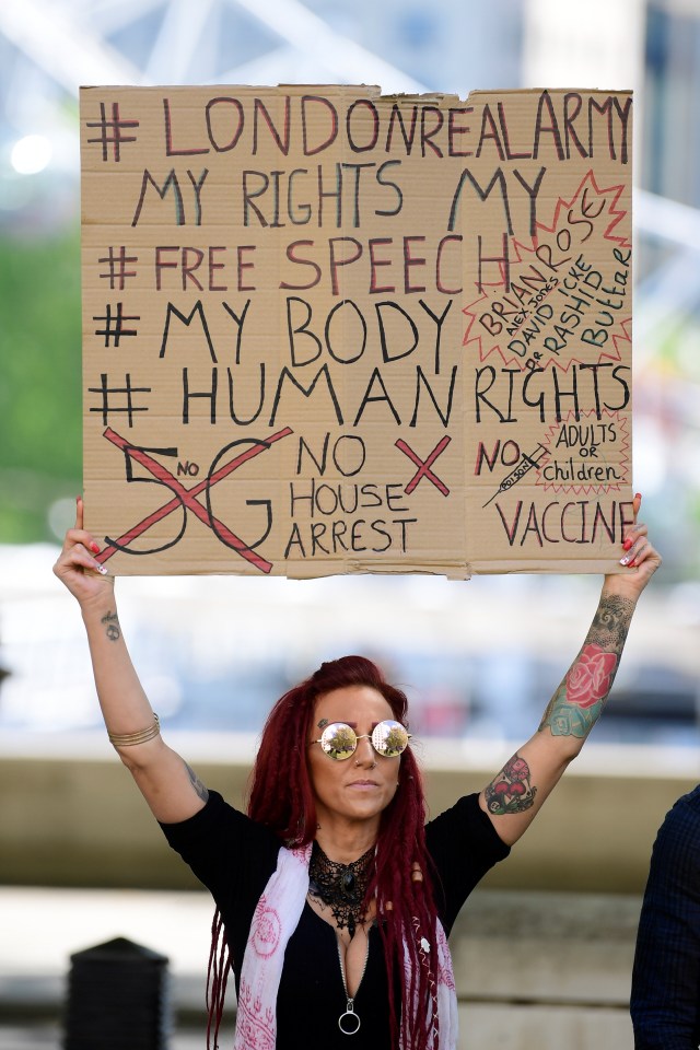  A woman holds up a sign protesting 'house arrest'