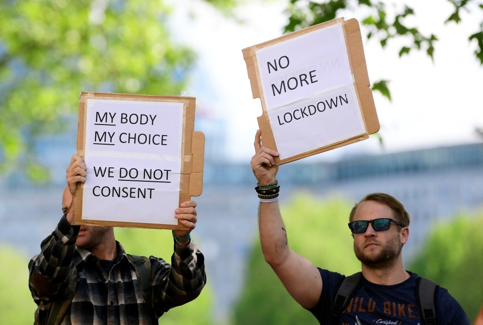  A man holds up a sign protesting the lockdown