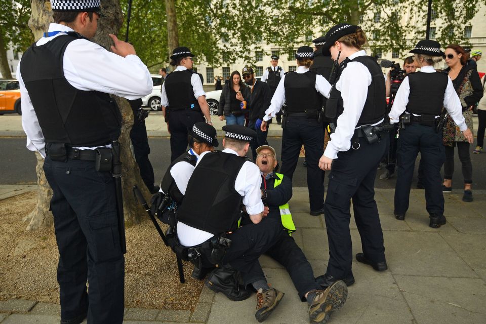  A man appears to yell as officers move him on