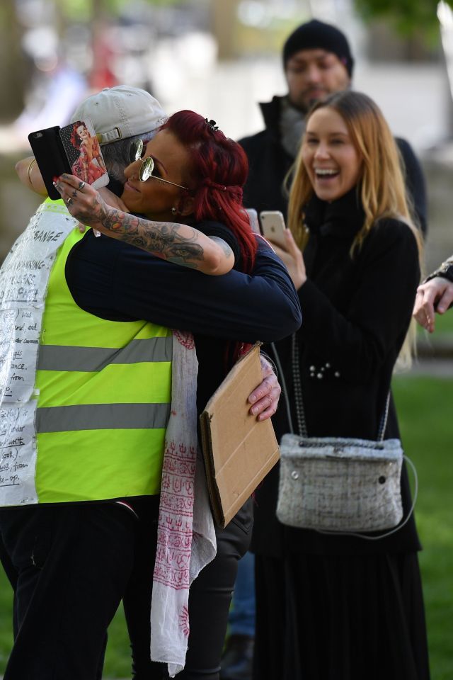  A woman smiles as two people hug during the protest