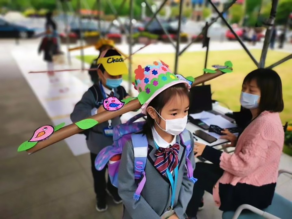  Children attending school in China wore social distancing hats as they returned to class