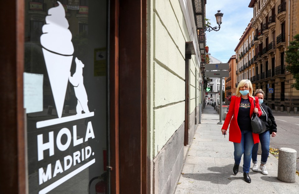  Women wearing protective masks walk past a closed ice cream shop amid the coronavirus disease outbreak in Madrid, Spain, May 5