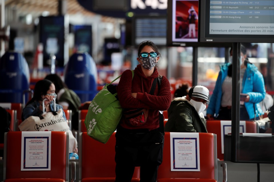  Passengers, wearing protective face masks, wait to board an Air France flight at Paris Charles de Gaulle airport on May 6