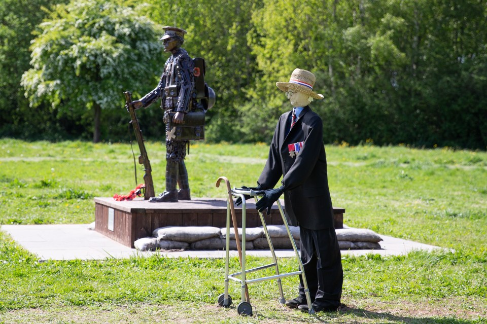  A tribute to Colonel Tom Moore stands next to a war memorial in Merseyside