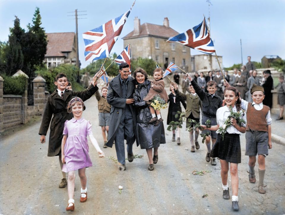  Children wave Union Jack flags and carry flowers as a beaming soldier returns home to Oreston, South Devon