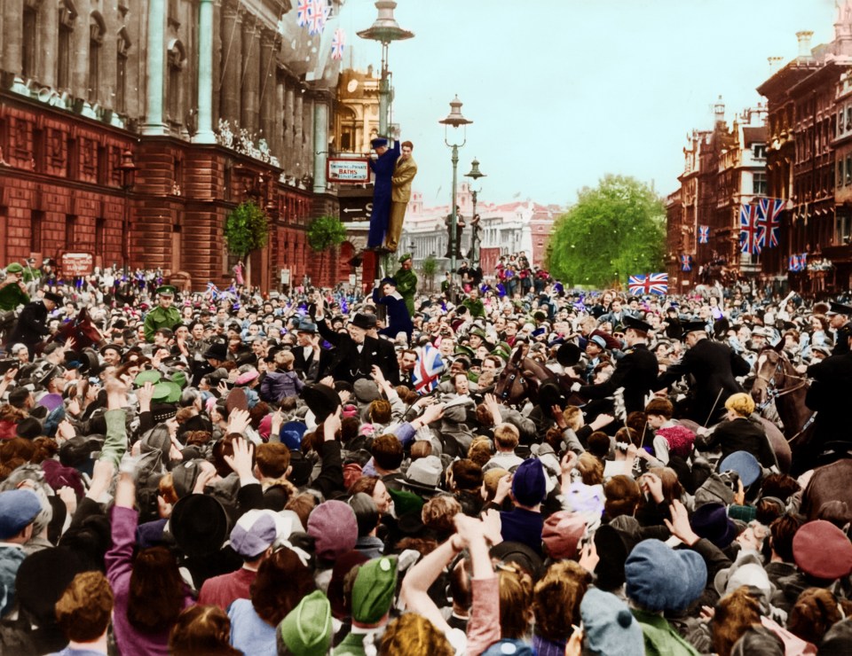 Wartime PM Winston Churchill gives his famous V for Victory sign, joining the huge crowd celebrating near London’s Whitehall on VE Day