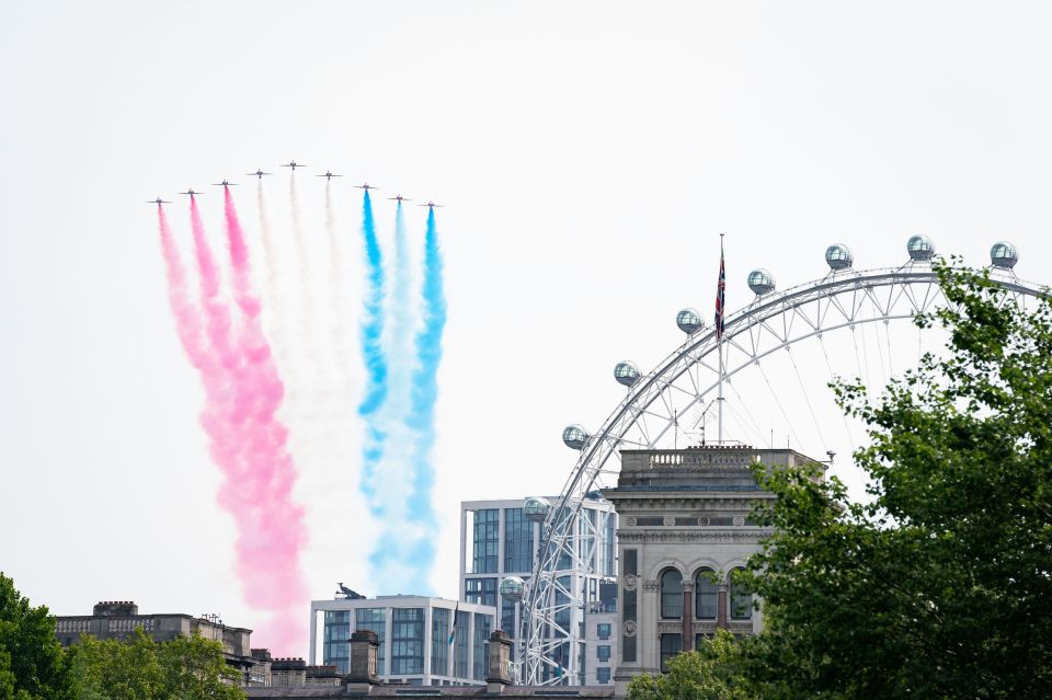  Red, white and blue smoke follows the Red Arrows as they speed above the London Eye