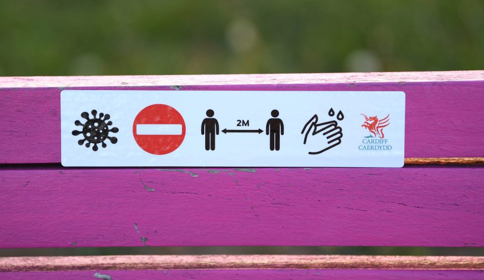  Social Distancing advice is seen in the shape of a sticker from Cardiff Council on a park bench