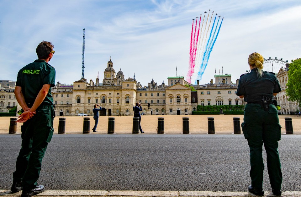 Paramedic Kerry Johnson, 28, who has been working 12-hour shifts, watches the flypast with a colleague