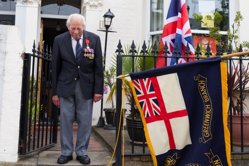  Royal Navy veteran, Charles Medhurst stands outside his decorated house in Greenwich during the two minute silence