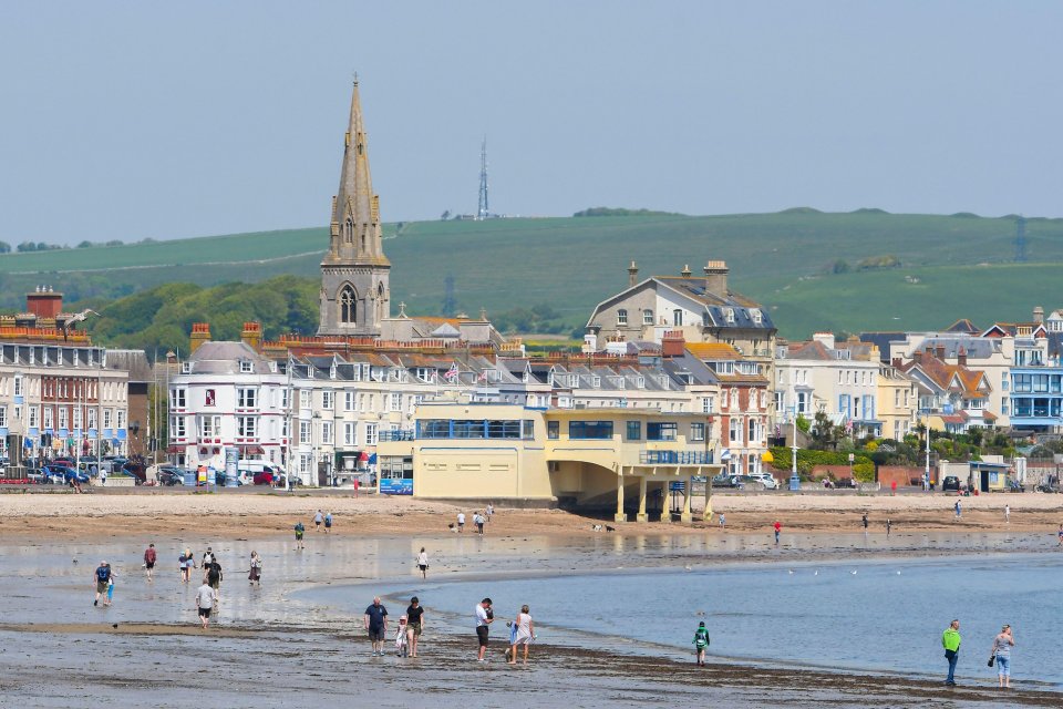  A busy scene with people exercising on the beach at the seaside resort of Weymouth