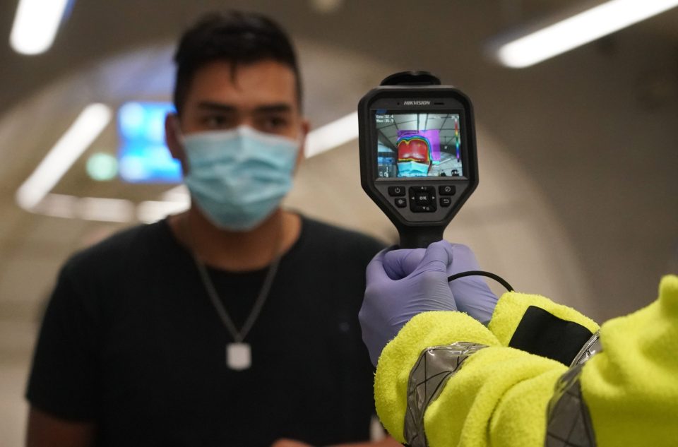  A volunteer takes a traveller's temperature at the metro station, after the Basque Country moved to Phase 1