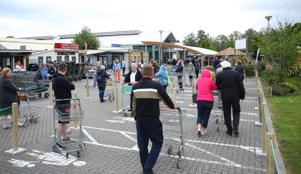  Customers wait in line to shop at the Longacre Garden Centre which reopened in Bagshot today