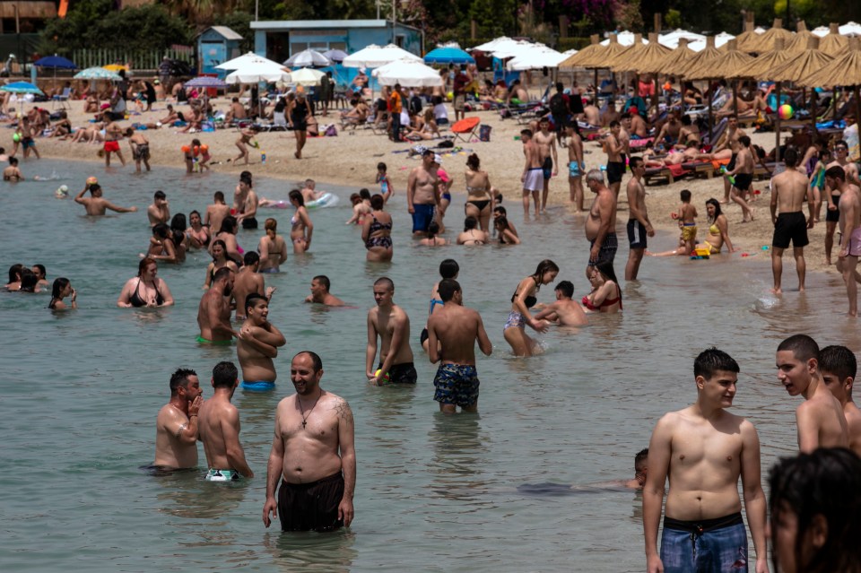  Crowds of people gather on a beach near Athens as restrictions are lifted in Greece