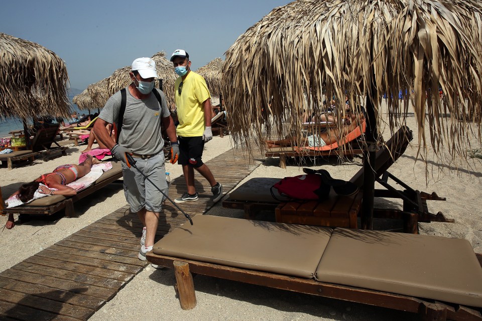  Employees disinfect a sunbed on a beach at the coastal zone of Athens, Greece