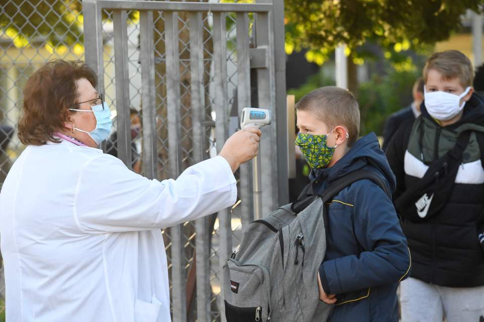  A schoolboy has his temperature checked at a school in France