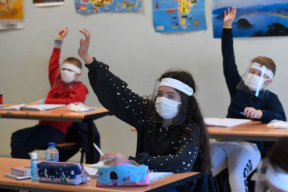  Schoolchildren wear protective mouth masks and face shields at a school in Angers, western France